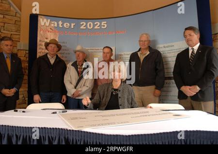 Segretario Gale Norton, centro, firmando Water 2025 Challenge Grant per il distretto di irrigazione di Springville nello Utah, durante la cerimonia a Orem, Utah, segnando l'attuazione di finanziamenti federali per 11 progetti di gestione dell'acqua nello Utah e uno nell'Idaho. Water 2025 promuove banche idriche volontarie, nuove tecnologie di conservazione e federali, statali, tribali, cooperazione privata in materia di conservazione Foto Stock