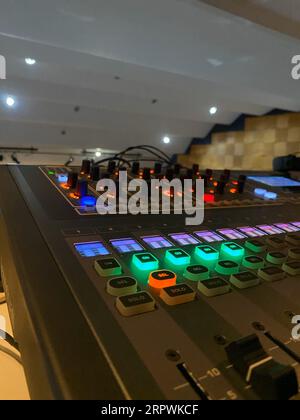 Una console di mixaggio audio con una varietà di manopole e quadranti multicolori Foto Stock