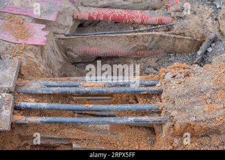 installazione di infrastrutture per cavi elettrici sotterranei. Cantiere con molti cavi di comunicazione protetti in tubi. elettrico e alta-spe Foto Stock