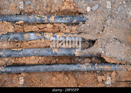 installazione di infrastrutture per cavi elettrici sotterranei. Cantiere con molti cavi di comunicazione protetti in tubi. elettrico e alta-spe Foto Stock