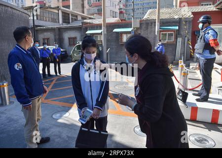 200511 -- PECHINO, 11 maggio 2020 -- Un insegnante dà un adesivo di benvenuto a uno studente che entra nella scuola media No. 166 a Pechino, capitale della Cina, 11 maggio 2020. Pechino lunedì ha ripreso le lezioni per gli studenti dell'ultimo anno di tutte le scuole medie superiori, mentre l'impatto della COVID-19 è andato via. CHINA-BEIJING-COVID-19-SCHOOL-RESUMPTION CN PENGXZIYANG PUBLICATIONXNOTXINXCHN Foto Stock