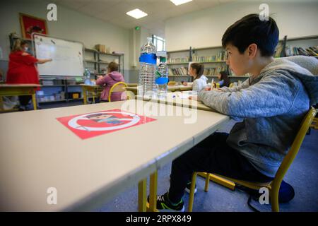 200512 -- NICE, 12 maggio 2020 Xinhua -- gli scolari frequentano una lezione alla Simone Veil Primary School di Nizza, Francia, 12 maggio 2020. Quasi due mesi dopo aver ordinato ai suoi 67 milioni di abitanti di rimanere a casa per arginare l'epidemia di coronavirus, la Francia lunedì ha cautamente avviato un processo graduale per tornare alla normalità, allentando alcune restrizioni e mantenendo altre per evitare una nuova ondata epidemica. Circa 1,5 milioni di bambini, ovvero il 22% del numero totale di alunni del paese, si preparano ad andare a scuola martedì, e 190.000 insegnanti hanno ripreso a lavorare lunedì, secondo il Ministero dell'istruzione Foto Stock