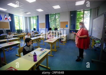 200512 -- NICE, 12 maggio 2020 Xinhua -- gli scolari frequentano una lezione alla Simone Veil Primary School di Nizza, Francia, 12 maggio 2020. Quasi due mesi dopo aver ordinato ai suoi 67 milioni di abitanti di rimanere a casa per arginare l'epidemia di coronavirus, la Francia lunedì ha cautamente avviato un processo graduale per tornare alla normalità, allentando alcune restrizioni e mantenendo altre per evitare una nuova ondata epidemica. Circa 1,5 milioni di bambini, ovvero il 22% del numero totale di alunni del paese, si preparano ad andare a scuola martedì, e 190.000 insegnanti hanno ripreso a lavorare lunedì, secondo il Ministero dell'istruzione Foto Stock