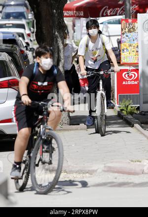 200513 -- ANKARA, 13 maggio 2020 Xinhua -- i bambini che indossano maschere facciali cavalcano le biciclette in una strada ad Ankara, Turchia, il 13 maggio 2020. I bambini sotto i 14 anni in Turchia sono stati ammessi all'esterno mercoledì per la prima volta in 40 giorni come parte del piano di normalizzazione COVID-19 del paese. Il numero totale di casi di COVID-19 in Turchia è salito a 143.114, mentre il bilancio delle vittime è salito a 3.952 mercoledì. Foto di Mustafa Kaya/Xinhua TURKEY-ANKARA-COVID-19-CASES PUBLICATIONxNOTxINxCHN Foto Stock