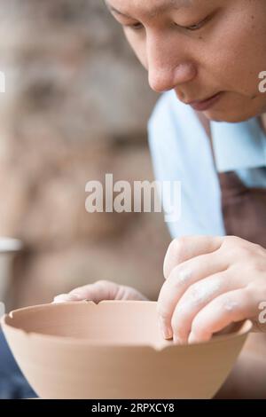 200517 -- HANGZHOU, 17 maggio 2020 -- Liu Jie lavora alla replica di Bakohan nel suo studio a Longquan, nella provincia dello Zhejiang, Cina orientale, 7 maggio 2020. Liu Jie, 35 anni e un rinomato ceramista a Longquan, iniziò a replicare Bakohan dal 2019. Finora ha realizzato oltre 500 repliche nel tentativo di avvicinarsi alla perfezione. Voglio replicare la sua bellezza. Ha detto Liu. Bakohan è una ciotola da tè prodotta a Longquan, in Cina, e donata al Giappone durante la dinastia Song meridionale 1127-1279. Durante l'era della dinastia Ming 1368-1644, Bakouhan fu scoperto avere crepe e fu quindi inviato in Cina per essere riparato. La ciotola è ora distribuita Foto Stock