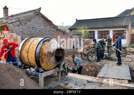 200520 -- KELAN, 20 maggio 2020 -- gli abitanti del villaggio rinnovano un cantiere nel nuovo villaggio di Songjiagou nella contea di Kelan, nella provincia dello Shanxi della Cina settentrionale, 9 maggio 2020. Kelan County si trova nella zona centrale del Loess Plateau e delle profonde montagne Lyuliang, con quasi la metà dei suoi villaggi che si trovano ad affrontare una scarsa produzione e condizioni di vita. Nel 2017 il governo locale ha implementato un piano di trasferimento per le famiglie povere in villaggi remoti come un passo chiave per alleviare la povertà e il nuovo villaggio di Songjiagou è diventato un sito centralizzato di trasferimento che assorbe 145 famiglie povere dai 14 villaggi circostanti. Negli ultimi anni, Foto Stock