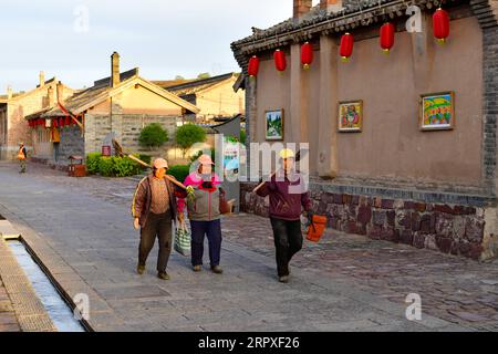 200520 -- KELAN, 20 maggio 2020 -- gli abitanti del villaggio camminano per strada al nuovo villaggio di Songjiagou nella contea di Kelan, nella provincia dello Shanxi della Cina settentrionale, 9 maggio 2020. Kelan County si trova nella zona centrale del Loess Plateau e delle profonde montagne Lyuliang, con quasi la metà dei suoi villaggi che si trovano ad affrontare una scarsa produzione e condizioni di vita. Nel 2017 il governo locale ha implementato un piano di trasferimento per le famiglie povere in villaggi remoti come un passo chiave per alleviare la povertà e il nuovo villaggio di Songjiagou è diventato un sito centralizzato di trasferimento che assorbe 145 famiglie povere dai 14 villaggi circostanti. Negli ultimi anni Foto Stock