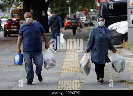 200521 -- ANKARA, 21 maggio 2020 Xinhua -- le persone con maschere facciali camminano in una strada dopo aver fatto shopping ad Ankara, Turchia, il 21 maggio 2020. Giovedì il ministro della sanità turco Fahrettin Koca ha confermato 961 nuovi casi giornalieri di COVID-19 e altri 27 decessi in Turchia. Il numero totale di casi confermati nel paese è salito a 153.548. Foto di Mustafa Kaya/Xinhua TURKEY-ANKARA-COVID-19-CASES PUBLICATIONxNOTxINxCHN Foto Stock