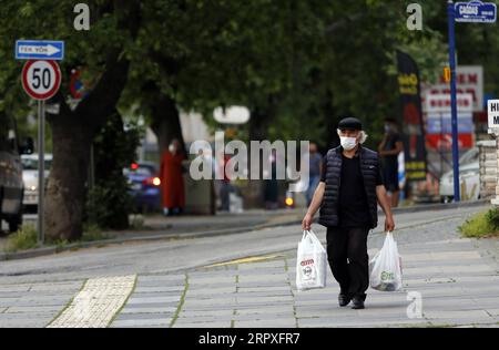 200521 -- ANKARA, 21 maggio 2020 Xinhua -- Un uomo che indossa una maschera cammina in una strada dopo aver fatto shopping ad Ankara, Turchia, il 21 maggio 2020. Giovedì il ministro della sanità turco Fahrettin Koca ha confermato 961 nuovi casi giornalieri di COVID-19 e altri 27 decessi in Turchia. Il numero totale di casi confermati nel paese è salito a 153.548. Foto di Mustafa Kaya/Xinhua TURKEY-ANKARA-COVID-19-CASES PUBLICATIONxNOTxINxCHN Foto Stock