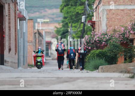 200527 -- GANGUGANSU, 27 maggio 2020 -- due figli di Niu Lijuan 1st e 2nd R Walk on their way to School at Liufeng Township of Tianshui City, North West China S Gansu Province, 26 maggio 2020. La 36enne Niu Lijuan è una cittadina del comune di Liufeng, ma anni fa ha dovuto lasciare migliaia di chilometri di distanza per lavorare a causa della mancanza di opportunità di lavoro nella sua città natale. Anche dopo la nascita del suo primo figlio, ha dovuto andare al lavoro e soffrire del dolore di mancare il suo neonato a casa. Negli ultimi anni, nella sua città natale si sono verificati profondi cambiamenti con il governo locale S p Foto Stock