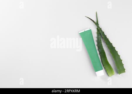 Tubo di dentifricio e aloe fresca su sfondo bianco, vista dall'alto Foto Stock