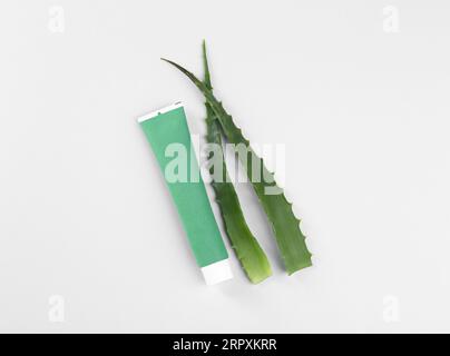 Tubo di dentifricio e aloe fresca su sfondo bianco, vista dall'alto Foto Stock