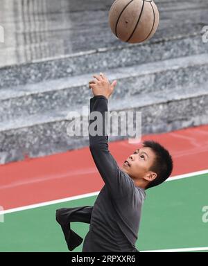 200605 -- YUNFU, 5 giugno 2020 -- Zhang Jiacheng gioca a basket prima del mattino in una scuola media nella città di Gaocun nella provincia del Guangdong, nella Cina meridionale, 4 giugno 2020. ANDARE CON un giocatore di basket cinese con un braccio solo di 13 anni diventa Internet Sensation CHINA-GUANGDONG-YUNFU CITY-DISABLED BOY-BASKET CN DengxHua PUBLICATIONxNOTxINxCHN Foto Stock