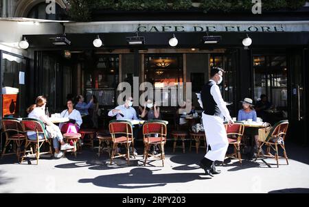 200610 -- PARIGI, 10 giugno 2020 -- la gente fa colazione sulla terrazza del Cafe de Flore a Parigi, Francia, 2 giugno 2020. Il governo francese ha deciso di porre fine allo stato di emergenza sanitaria il 10 luglio, due settimane prima della data precedentemente prevista, e si prevede di mantenere un certo potere per limitare la libertà nei prossimi mesi di contenere la diffusione del coronavirus, quotidiano francese le Monde riportato mercoledì. La Francia, uno dei paesi europei più colpiti dalla pandemia di coronavirus, ha dichiarato lo stato di emergenza sanitaria il 24 marzo. FRANCIA-PARIGI-COVID-19-STATO DI EMERGENZA SANITARIA GAOXJING PUB Foto Stock