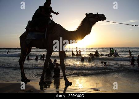 200613 -- PECHINO, 13 giugno 2020 -- i palestinesi si godono il loro tempo durante il tramonto al mare nella città di Gaza, il 12 giugno 2020. Foto di /Xinhua XINHUA FOTO DEL GIORNO RizekxAbdeljawad PUBLICATIONxNOTxINxCHN Foto Stock