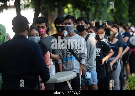 200614 -- GIACARTA, 14 giugno 2020 -- le persone aspettano di avere la temperatura corporea controllata per entrare nella zona GBK di Gelora Bung Karno a Giacarta, Indonesia, 14 giugno 2020. INDONESIA-GIACARTA-COVID-19-ATTIVITÀ-EASING VerixSanovri PUBLICATIONxNOTxINxCHN Foto Stock