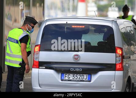 200615 -- MENTONE FRANCIA, 15 giugno 2020 Xinhua -- Un gendarme controlla un veicolo italiano al confine tra Francia e Italia a Mentone, nel sud della Francia, il 15 giugno 2020. In un discorso televisivo alla nazione di domenica, il presidente francese Emmanuel Macron dichiarò una prima vittoria sull'epidemia di coronavirus, annunciando un ritorno alla normalità da lunedì in tutte le regioni francesi, ad eccezione dei territori d'oltremare. A partire da lunedì, i viaggiatori europei potranno entrare in territorio francese senza restrizioni, mentre quelli provenienti da paesi al di fuori dello spazio Schengen dovranno attendere fino al 1° luglio. Foto di Serge Hao Foto Stock