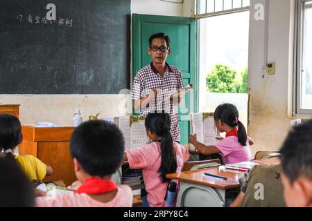 200620 -- WUXUAN, 20 giugno 2020 -- Wei Xuxi dà una lezione alla scuola primaria Shuanggui nella città di Ertang della contea di Wuxuan, nella regione autonoma di Guangxi Zhuang, nella Cina meridionale, 19 giugno 2020. Wei Xuxi, un insegnante di 57 anni di Ertang Town nella contea di Wuxuan, ha trascorso oltre 30 anni a insegnare in campagna dopo essersi diplomato al liceo nel 1985. Ci sono 32 studenti in due classi alla Shuanggui Primary School, una scuola su piccola scala dove lavora Wei. Invece di edifici fatiscenti, o tavoli e sedie rotti, la multimedialità e molte altre attrezzature didattiche avanzate rendono la scuola lontana dalla povera e fac Foto Stock