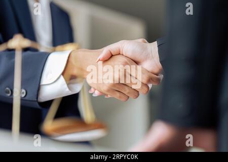 Uomo d'affari che stringe la mano per concludere un accordo con i suoi avvocati partner o avvocati che discutono di un accordo contrattuale Foto Stock