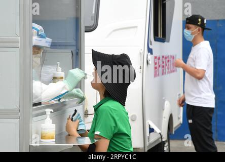 200624 -- PECHINO, 24 giugno 2020 -- Un operatore medico raccoglie un tampone alla gola da un residente in un'unità di analisi degli acidi nucleici in un sito di campionamento dell'ospedale Beijing Anzhen, Pechino, capitale della Cina, 24 giugno 2020. Le unità di test degli acidi nucleici e le cabine mobili sono state messe in uso nell'ospedale di Pechino Anzhen per aiutare a raccogliere i campioni di tampone per l'analisi degli acidi nucleici in modo più efficiente. CHINA-BEIJING-COVID-19-NUCLEIC ACID TESTING-MOVABLE CABIN-UNITCN RENXCHAO PUBLICATIONXNOTXINXCHN Foto Stock