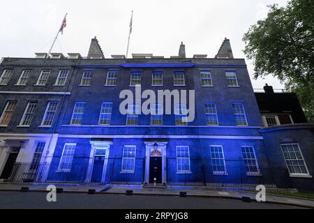 200705 -- LONDRA, 5 luglio 2020 Xinhua -- Una candela è posta di fronte a Downing Street mentre l'edificio è illuminato di blu per celebrare il 72° anniversario del National Health Service NHS a Londra, in Gran Bretagna, il 4 luglio 2020. Secondo i media locali, dozzine di punti di riferimento in tutto il paese sono stati illuminati di blu per segnare i 72 anni dalla fondazione dell'NHS. Foto di Ray Tang/Xinhua BRITAIN-LONDON-LANDMARKS-LIT BLUE-NHS-72ND ANNIVERSARY PUBLICATIONxNOTxINxCHN Foto Stock