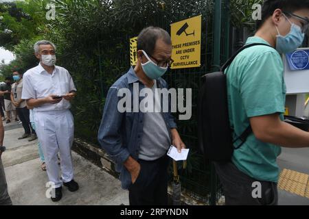 200710 --SINGAPORE, 10 luglio 2020 -- il primo ministro di Singapore Lee Hsien Loong 1st L si mette in fila per entrare in un collegio elettorale per esprimere il suo voto per le elezioni generali a Singapore il 10 luglio 2020. SINGAPORE-ELEZIONI GENERALI-VOTO ThenxChihxWey PUBLICATIONxNOTxINxCHN Foto Stock