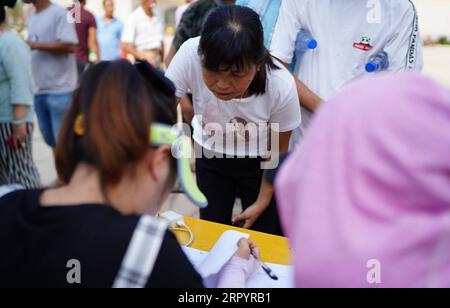 200713 -- JIUJIANG, 13 luglio 2020 -- le persone si mettono in fila per la registrazione in un sito di reinsediamento nella scuola di Hudong nella contea di Yongxiu, nella provincia di Jiangxi della Cina orientale, 13 luglio 2020. L'argine di un fiume nella contea di Yongxiu è stato violato domenica sera a seguito di continue piogge torrenziali, costringendo i residenti locali ad evacuare. CHINA-JIANGXI-JIUJIANG-CONTROLLO DELLE INONDAZIONI CN ZHOUXMI PUBLICATIONXNOTXINXCHN Foto Stock