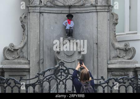 200714 -- BRUXELLES, 14 luglio 2020 -- Un visitatore scatta foto del Manneken-Pis che indossa un abito con berretto e baguette a Bruxelles, in Belgio, 14 luglio 2020. Manneken-Pis, il simbolo del folklore di Bruxelles, indossa i costumi nei principali eventi. Indossava un abito con berretto e baguette il martedì per commemorare la giornata nazionale francese che cade il 14 luglio di ogni anno. BELGIO-BRUXELLES-MANNEKEN-PIS-GIORNATA NAZIONALE FRANCESE ZHENGXHUANSONG PUBLICATIONXNOTXINXCHN Foto Stock