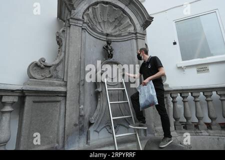 200714 -- BRUXELLES, 14 luglio 2020 -- un comò ufficiale si prepara a vestire i Manneken-Pis a Bruxelles, in Belgio, 14 luglio 2020. Manneken-Pis, il simbolo del folklore di Bruxelles, indossa i costumi nei principali eventi. Indossava un abito con berretto e baguette il martedì per commemorare la giornata nazionale francese che cade il 14 luglio di ogni anno. BELGIO-BRUXELLES-MANNEKEN-PIS-GIORNATA NAZIONALE FRANCESE ZHENGXHUANSONG PUBLICATIONXNOTXINXCHN Foto Stock