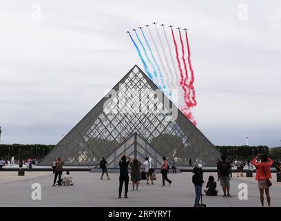 200714 -- PARIGI, 14 luglio 2020 -- l'aeronautica francese Patrouille de France sorvola la piramide del Museo del Louvre durante la celebrazione del giorno della Bastiglia a Place de la Concorde a Parigi, in Francia, 14 luglio 2020. Senza la tradizionale parata militare lungo il famoso viale degli Champs Elysees e la celebrazione pubblica, martedì il presidente francese Emmanuel Macron ha presieduto la cerimonia del giorno della Bastiglia offuscata dalla crisi del coronavirus. Per la celebrazione di quest'anno, la parata militare, che tradizionalmente attirava una folla enorme, è stata cancellata per la prima volta dal 1945 e sostituita da a d Foto Stock