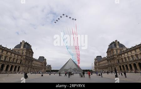 200714 -- PARIGI, 14 luglio 2020 -- l'aeronautica francese Patrouille de France sorvola la piramide del Museo del Louvre durante la celebrazione del giorno della Bastiglia a Place de la Concorde a Parigi, in Francia, 14 luglio 2020. Senza la tradizionale parata militare lungo il famoso viale degli Champs Elysees e la celebrazione pubblica, martedì il presidente francese Emmanuel Macron ha presieduto la cerimonia del giorno della Bastiglia offuscata dalla crisi del coronavirus. Per la celebrazione di quest'anno, la parata militare, che tradizionalmente attirava una folla enorme, è stata cancellata per la prima volta dal 1945 e sostituita da a d Foto Stock