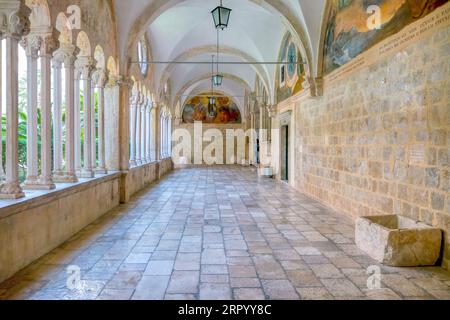 Dubrovnik, Croazia - 3 giugno 2016. Un corridoio interno del monastero francescano medievale nella città vecchia, con un cortile interno visibile. Foto Stock