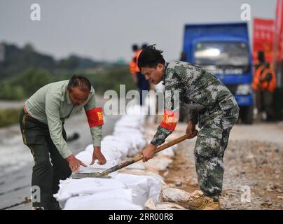 200721 -- JIUJIANG, 21 luglio 2020 -- Chen Shentao L e suo figlio Chen Jian rafforzano un argine minacciato da inondazioni nella città di Xin gang della città di Jiujiang, provincia di Jiangxi della Cina orientale, 18 luglio 2020. Non lascerò l'argine fino a quando le inondazioni non si ritireranno, promesso Chen Shentao, capo del partito comunista del villaggio di Jiangji a Xin gang Town, quando il villaggio fu colpito da disastrose inondazioni nel 1998. Chen era in prima linea nella lotta contro le inondazioni con gli abitanti del villaggio per oltre tre mesi. I suoi importanti contributi nella lotta alle inondazioni del 1998 gli valsero diversi onori nell'anno, quando lo fu Foto Stock