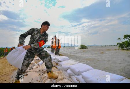 200721 -- JIUJIANG, 21 luglio 2020 -- il figlio di Chen Shentao Chen Jian L rafforza un argine nella città di Xin gang della città di Jiujiang, provincia di Jiangxi della Cina orientale, 18 luglio 2020. Non lascerò l'argine fino a quando le inondazioni non si ritireranno, promesso Chen Shentao, capo del partito comunista del villaggio di Jiangji a Xin gang Town, quando il villaggio fu colpito da disastrose inondazioni nel 1998. Chen era in prima linea nella lotta contro le inondazioni con gli abitanti del villaggio per oltre tre mesi. I suoi importanti contributi nella lotta alle inondazioni del 1998 gli valsero diversi onori nell'anno, quando suo figlio Chen Jian aveva solo 14 anni Foto Stock