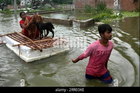 News Bilder des Tages 200726 -- BIHAR INDIA, 26 luglio 2020 -- Un ragazzo porta la madre e il bestiame in una barca improvvisata in un villaggio del distretto di Muzaffarpur, nello stato orientale indiano del Bihar, 26 luglio 2020. Almeno 10 persone sono state uccise e quasi 1,5 milioni di persone sono state colpite dalle inondazioni in 11 distretti nello stato orientale indiano del Bihar, ha detto in un bollettino domenica il dipartimento statale per la gestione dei disastri. Str/Xinhua INDIA-BIHAR-ALLUVIONI ParthaxSarkar PUBLICATIONxNOTxINxCHN Foto Stock