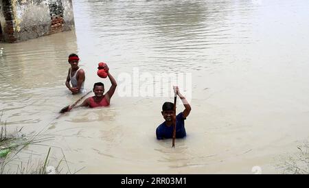 200726 -- BIHAR INDIA, 26 luglio 2020 -- gli abitanti del villaggio hanno attraversato le inondazioni nel distretto di Muzaffarpur, nello stato orientale indiano del Bihar, il 26 luglio 2020. Almeno 10 persone sono state uccise e quasi 1,5 milioni di persone sono state colpite dalle inondazioni in 11 distretti nello stato orientale indiano del Bihar, ha detto in un bollettino domenica il dipartimento statale per la gestione dei disastri. Str/Xinhua INDIA-BIHAR-ALLUVIONI ParthaxSarkar PUBLICATIONxNOTxINxCHN Foto Stock