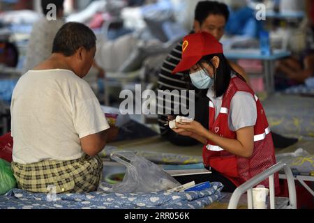 200729 -- HEFEI, 29 luglio 2020 -- Un volontario registra la domanda di medicine di un villaggio in un rifugio temporaneo nella scuola media No.168 a Hefei, nella provincia di Anhui della Cina orientale, 29 luglio 2020. Colpiti dalle inondazioni, più di 300 abitanti del villaggio a Sanhe Town di Hefei sono stati trasferiti alla scuola. Pasti gratuiti, consulenza psicologica e assistenza quotidiana sono forniti nel rifugio. CHINA-ANHUI-HEFEI-FLOOD-TEMPORARY SHELTER CN ZHOUXMU PUBLICATIONXNOTXINXCHN Foto Stock