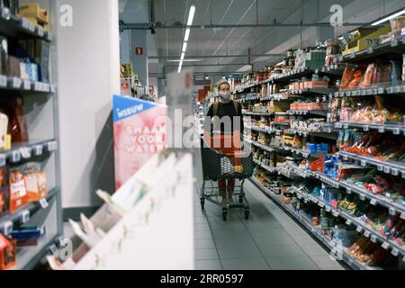 200729 -- BRUXELLES, 29 luglio 2020 -- Un cliente che indossa una maschera facciale negozi in un supermercato a Bruxelles, Belgio, 29 luglio 2020. Lunedì il primo ministro belga Sophie Wilmes ha annunciato nuove misure anti-COVID-19 adottate dal Consiglio di sicurezza nazionale NSC per evitare di imporre nuovamente un blocco generale nel paese. A partire da luglio 29 e per un minimo di quattro settimane, il numero di persone in una bolla di contatto sociale che attualmente è a 15 sarà ridotto a cinque per ogni famiglia. I bambini sotto i 12 anni non sono inclusi. BELGIO-BRUXELLES-COVID-19-LOCKDOWN-NEW STEPS ZHANGXCHENG PUBLICATIONXNOTXI Foto Stock