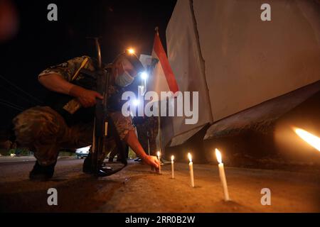 200806 -- BAGHDAD, 6 agosto 2020 Xinhua -- un membro della sicurezza irachena mette una candela per mostrare solidarietà al popolo libanese di fronte all'ambasciata libanese nel centro di Baghdad, Iraq, il 6 agosto 2020. Xinhua IRAQ-BAGHDAD-BEIRUT ESPLOSIONI-SOLIDARIETÀ PUBLICATIONxNOTxINxCHN Foto Stock