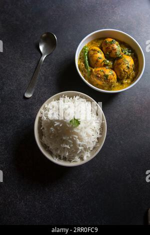 Piatti cotti, riso e curry all'uovo serviti in ciotole. Vista dall'alto, messa a fuoco selettiva. Foto Stock