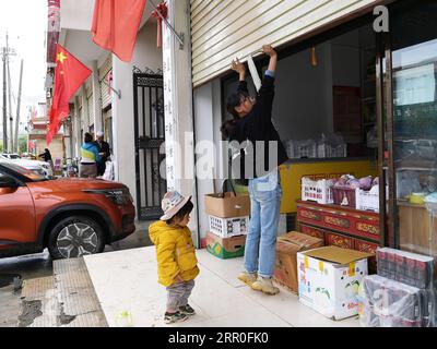 200813 -- LHASA, 13 agosto 2020 -- Gesang Wangmo apre la porta della tapparella per iniziare un giorno di attività nel suo negozio di verdure nella contea di Bainang, Xigaze, regione Autonoma del Tibet nel sud-ovest della Cina, 3 agosto 2020. Quando si è laureata in un college professionale nel 2018, Gesang Wangmo ha iniziato un'attività di giardinaggio ortofrutticolo con la sorella maggiore Degyi Zhoima nella loro città natale Bainang County, un'importante base di produzione vegetale in Tibet. Sostenute da fondi governativi, le sorelle avevano costruito 13 serre nel 2019 e incrementato le entrate introducendo nuove specie di colture e tecnologie di coltivazione Foto Stock