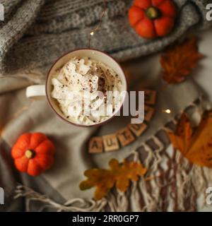 Composizione autunnale - Pumpkin Spice latte, foglie d'acero e zucche su sfondo nero, lay piatto creativo, vista dall'alto, spazio copia. Foto Stock