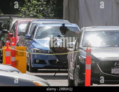 200814 -- VANCOUVER, 14 agosto 2020 -- Un operatore sanitario raccoglie un tampone da una donna in una struttura di test COVID-19 a Vancouver, British Columbia, Canada, il 14 agosto 2020. La curva COVID-19 della Columbia Britannica sta ora salendo a un tasso più alto rispetto all'epidemia iniziale di marzo, e la nuova modellazione provinciale mostra che B.C. potrebbe vedere una seconda ondata più grande della prima entro settembre. Foto di /Xinhua CANADA-VANCOUVER-COVID-19-TEST LiangxSen PUBLICATIONxNOTxINxCHN Foto Stock