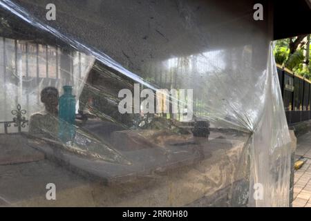 I membri delle forze di sicurezza indiane stanno di guardia con una mitragliatrice dietro un foglio di plastica davanti all'edificio del quartier generale della polizia del Maharashtra il 29 agosto 2023 a Mumbai, India. Mumbai, Foto Stock