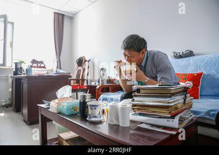 200817 -- PECHINO, 17 agosto 2020 -- Liu Qingquan pranza durante una pausa nel suo ufficio presso l'ospedale di Pechino di Medicina tradizionale Cinese a Pechino, capitale della Cina, 14 agosto 2020. Liu è il presidente dell'ospedale di Pechino di Medicina tradizionale Cinese TCM. A gennaio si è recato a Wuhan come membro del team di esperti di alto livello della Commissione sanitaria nazionale per studiare la risposta locale alla COVID-19 ed è diventato il capo dell'ospedale temporaneo Jiangxia, un ospedale temporaneo orientato alla TCM a Wuhan. Il lavoro di Liu e di altri esperti del team di Wuhan ha spianato la strada a un profondo coinvolgimento del TCM in Foto Stock