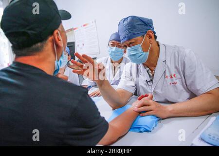 200817 -- PECHINO, 17 agosto 2020 -- Liu Qingquan R esamina un paziente all'ospedale di Pechino di Medicina tradizionale Cinese a Pechino, capitale della Cina, 11 agosto 2020. Liu è il presidente dell'ospedale di Pechino di Medicina tradizionale Cinese TCM. A gennaio si è recato a Wuhan come membro del team di esperti di alto livello della Commissione sanitaria nazionale per studiare la risposta locale alla COVID-19 ed è diventato il capo dell'ospedale temporaneo Jiangxia, un ospedale temporaneo orientato alla TCM a Wuhan. Il lavoro di Liu e di altri esperti del team di Wuhan ha spianato la strada a un profondo coinvolgimento della TCM nella lotta contro Foto Stock