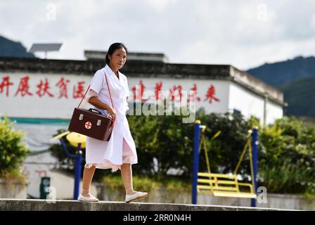 200821 -- LONGLI, 21 agosto 2020 -- Luo Mu è sulla strada per visitare un paziente nel villaggio di Cuiwei della contea di Longli, prefettura autonoma di Qiannan Buyi-Miao, provincia di Guizhou nella Cina sud-occidentale, 18 agosto 2020. Luo Mu, 49 anni, medico del gruppo etnico Buyi, lavora nel villaggio di Cuiwei della contea di Longli. Laureata in medicina nel 2004, è tornata al villaggio come medico. Trasformò il suo soggiorno in una clinica con le attrezzature mediche che aveva acquistato, per curare i pazienti del villaggio. Nel 2007, Luo fu impiegato in una clinica di nuova fondazione nel villaggio con una popolazione di 2 persone Foto Stock