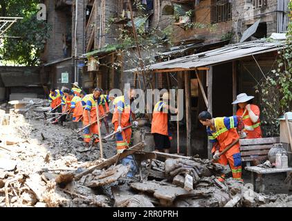 200823 -- CHONGQING, 23 agosto 2020 -- i lavoratori sanitari puliscono una strada a Guojiatuo nel distretto di Jiangbei nel comune di Chongqing della Cina sud-occidentale, 23 agosto 2020. Qui sono in corso lavori di soccorso in caso di catastrofi, mentre le acque alluvionali si ritirano. CHINA-CHONGQING-ALLUVIONE CN WangxQuanchao PUBLICATIONxNOTxINxCHN Foto Stock