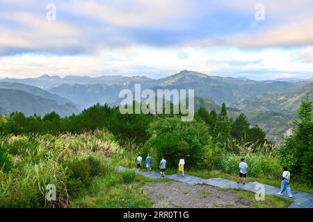 200825 -- FUZHOU, 25 agosto 2020 -- People Walk on a Tourist pathway in Chenqiao Village, Zhouning County, South East China S Fujian Province, 3 agosto 2020. Circondato da alte montagne e seduto in cima a una scogliera a strapiombo, Chenqiao è un villaggio millenario nella provincia del Fujian, famoso per le sue valli, le cascate e il mare di nuvole. Con un'altitudine di 936 metri e una temperatura media di 24 gradi Celsius in estate, è anche una delle mete preferite dai turisti. Dall'inizio dell'estate, un numero sempre maggiore di visitatori è attratto da escursioni, campeggi e visite turistiche. Foto Stock