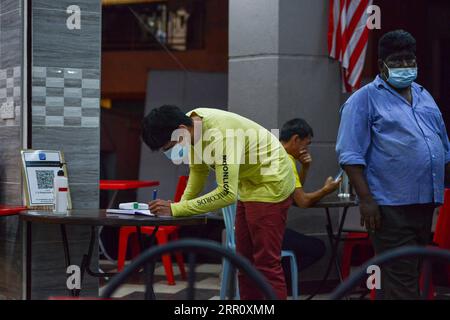 200828 -- KUALA LUMPUR, 28 agosto 2020 -- Un uomo scrive le sue informazioni prima di entrare in un ristorante a Kuala Lumpur, Malesia, 28 agosto 2020. La Malaysia continuerà ad imporre la fase di ripresa delle misure per il controllo dei movimenti al fine di contenere la COVID-19 fino al dicembre 31, ha affermato venerdì il primo ministro Muhyiddin Yassin, citando i rischi posti dalla continua diffusione della pandemia a livello mondiale. Foto di /Xinhua MALAYSIA-KUALA LUMPUR-COVID-19-MOVEMENT CONTROL ORDER-EXTENSION ChongxVoonxChung PUBLICATIONxNOTxINxCHN Foto Stock